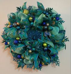 a green wreath with blue and gold ornaments