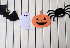 three halloween decorations hanging on a line