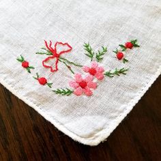 "This listing is for an embroidered vintage handkerchief. Made of linen and with a rolled edge, there is an embroidered pink daisy like flower posey tied in a red bow embroidered in one corner. There is one small spot that has been faintly stained and a tiny hole was created, see picture. Handy retro gift for someone who has allergies or will cry the happiest of tears on someone's wedding day.  Use it as it was intended as a handkerchief. Or... frame it in an embroidery hoop and displayed with o Traditional Floral Embroidered Handkerchiefs As Gift, Embroidered Flower Handkerchiefs For Gifts, Flower-shaped Embroidered Handkerchiefs For Gifts, Flower Shaped Embroidered Handkerchiefs For Gift, Embroidered Flower Handkerchiefs As Gift, Embroidered Pink Handkerchiefs For Gifts, White Embroidered Flower Shaped Handkerchiefs, Spring Handkerchiefs With Floral Embroidery As Gift, Floral Embroidered Handkerchiefs For Spring Gift