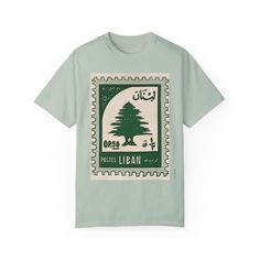 A green Lebanese post stamp print on this T-shirt gives off a vintage and cultural vibe. Perfect for those who appreciate unique and artistic designs. Ideal for casual wear or as a statement piece on special occasions. Product features - Available in sizes S to 4XL for the perfect fit - Double-needle stitching for durability - Garment-dyed fabric for a soft texture - Made with 100% ring-spun US cotton for comfort - Relaxed fit and crew neckline for versatile styling Care instructions - Machine w Casual Green T-shirt With Print, Casual Green Printed T-shirt, Green Cotton T-shirt With Print, Vintage Cotton Printed T-shirt, Vintage Green Shirt With Screen Print, Stamp Shirt, Stamp Print, Postal Vintage, Stamp Printing