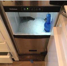 an ice maker is shown in the middle of a freezer filled with ice and water