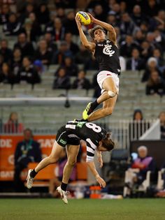 two men jumping in the air to catch a frisbee at a sporting event