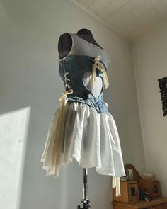 a mannequin dressed in white and blue with bows on it's back