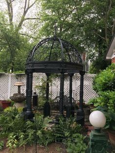 an outdoor gazebo surrounded by plants and trees