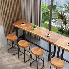 four stools and a table in front of a large window with cityscape