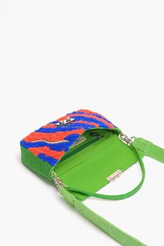 Colorful front embellishment Dual handles: Beaded top handle and detachable shoulder strap Padlock mini clasp closure Lined interior with zip pocket Front embellished and embroidered Dimensions: 10 x 5 x 2 inches, belt length 40 x 1.25 inches Introducing our Colorburst Harmony Shoulder Bag, a vibrant and stylish accessory that is sure to catch everyone's attention. This colorful purse features a strap and a green handle, adding a unique touch to your outfit.Designed with both fashion and functio Party Evening Bag With Top Handle And Adjustable Strap, Party Evening Bag With Adjustable Top Handle, Multicolor Crossbody Clutch For Evening, Party Clutch Satchel With Adjustable Strap, Party Clutch With Adjustable Strap And Satchel Shape, Party Clutch With Adjustable Strap Satchel, Multicolor Party Bag With Zipper Closure, Multicolor Crossbody Clutch For Party, Embellished Multicolor Bags As Fashion Accessory