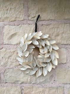 a paper wreath hanging on a brick wall