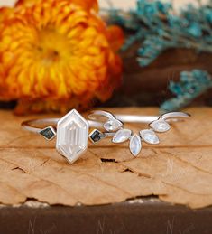 a close up of a ring on a piece of paper with flowers in the background