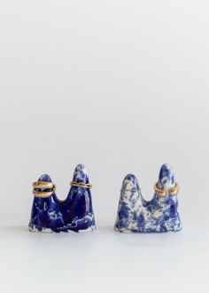 two blue and white ceramic objects sitting next to each other on a white table top