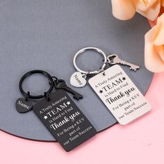 two keychains that say thank and have names on them