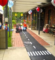 a race car is going down the street with balloons