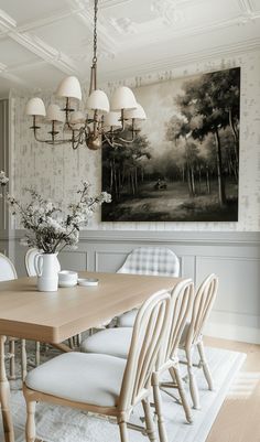 a dining room table with white chairs and a large painting on the wall behind it