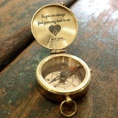 a brass compass sitting on top of a wooden table