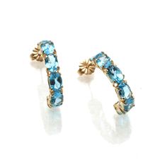 "This is a stunning pair of vintage earrings! These lovely earrings are made of 14k yellow gold. They are hoop earrings, each one set with 6 oval cut vibrant Swiss blue topaz stones. The total carat weight of the (12) stones is 6.03 carats. They are posts with nut backings. They are bright and comfortable to wear! The earrings measures approximately 7/8\" long by 1/4\" wide. They come in a pouch perfect for safekeeping or gift giving. Please check out my other items, I will combine shipping!" Formal Yellow Gold Hoop Earrings With Gemstones, Formal Yellow Gold Gemstone Hoop Earrings, Anniversary Yellow Gold Earrings With Blue Topaz, Anniversary Yellow Gold Blue Topaz Earrings, Elegant Blue 14k Gold Hoop Earrings, Luxury Oval Blue Topaz Earrings, Elegant Oval Hoop Earrings With Gemstone, Classic Yellow Gold Hoop Earrings With Gemstone, Oval 14k Gold Earrings With 17 Jewels