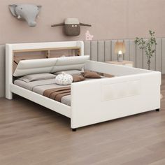 a white bed sitting on top of a hard wood floor