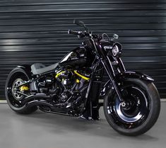 a black motorcycle parked in front of a garage door