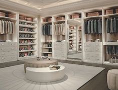 a large walk in closet with lots of clothes