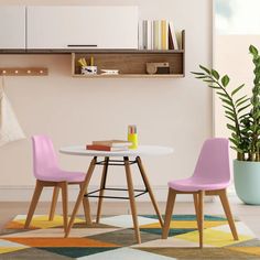 a white table with two chairs next to a plant and bookshelf on the wall