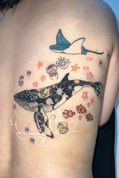 a woman with a tattoo on her chest has an image of a whale and fish