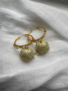 Bollywood Jhumkas in pastel green with pretty enamel flowers, gold hoops, and little pearl accent.  South Asian jewelry for special occasions. Perfect with lehenga, saree, Kurtis, and everything in between. Please be sure to check out my shop policy and jewelry care instructions before you place an order! **Since this is a special occasion jhumkas, they are a bit heavy.  Thank you for visiting my shop! Feel free to follow me on Instagram: @nakkalinaani Pastel Green Earrings, Luxury Green Jhumkas For Festivals, Simple Jhumka Earrings, Green Jhumka Earrings, Green Meenakari Lehenga For Diwali, Green Meenakari Lehenga For Festivals, Festive Green Meenakari Lehenga, Desi Jewelry Simple, Pista Green Meenakari Lehenga For Festivals