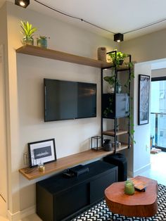 a living room with black and white rugs and a flat screen tv mounted on the wall