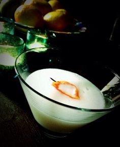 a glass bowl filled with liquid next to some lemons