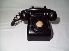 an old fashioned black telephone on a white background