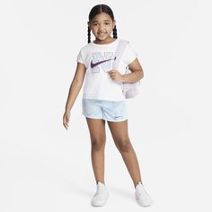 This 2-piece performance set was designed to put a little extra pep in your kiddo's step! The tee is made of knit fabric with short dolman sleeves and a flowy boxy cut for a relaxed fit with a flattering cropped look. The matching shorts are made of lightweight woven fabric, have an encased elastic waistband for a comfy fit and a built-in liner providing full coverage during every run, jump and skip. Additionally, both pieces are enhanced with quick-drying, moisture-wicking Dri-FIT technology to Sportswear Tops For Playwear, Short Sleeve Sportswear Tops For Play, Sporty T-shirt For Summer Playtime, Sporty T-shirt For Playwear In Spring, Nike Sporty T-shirt For Play, Sporty T-shirt For Spring Playwear, Sporty Spring T-shirt For Playwear, White Athleisure Tops For Playwear, Nike Athleisure Tops For Playwear