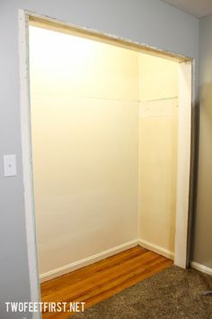 an empty room with white walls and wood flooring in front of the closet door