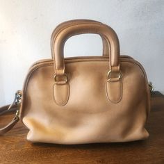 Color: Tan - 100% Leather - Shoulder Strap - Grosgrain Lining & Interior Pockets - Zip Closure At Top - Protective Feet At Base - Style# 069-8126 (*Mild Wear Throughout, As Seen In Photos*) Dimensions: - Handle Drop: 4.5" - 8"H X 11.75"W X 4.75"D Classic Handheld Bag With Leather Lining, Vintage Coach Satchel With Handles, Vintage Coach Bag With Double Handle, Coach Shoulder Bag With Leather Lining And Double Handle, Coach Double Handle Shoulder Bag With Leather Lining, Classic Beige Soft Leather Satchel, Vintage Beige Leather Bags, Coach Beige Soft Leather Satchel, Coach Soft Leather Beige Satchel