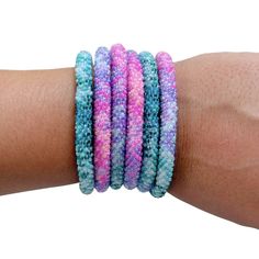 a woman's arm with several bracelets on top of each other in different colors