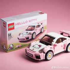 a pink car with hello kitty decals on it's hood is next to a box