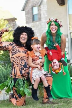 three people dressed in costumes posing for a photo with one child and the other adult