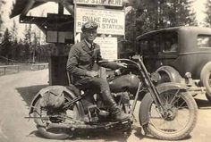 an old black and white photo of a man on a motorcycle