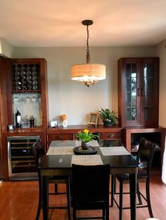 a dinning room table with chairs and a potted plant on top of it