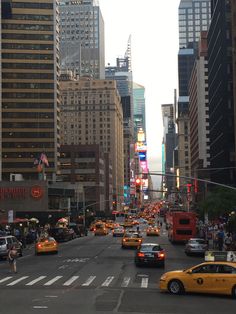 a city street filled with lots of traffic next to tall buildings on either side of the road