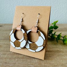 These soccer hoop earrings pair perfectly with any look to get your ready for the season ahead. Featuring hand painted wood, leather and metal findings. Approximately 2.5” x 1.5” Soccer Earrings, Laser Ideas, Wood Earring, Wild Orchid, Earring Ideas