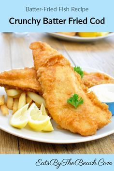 a white plate topped with fried fish and fries