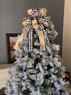 a christmas tree decorated with black and white bows