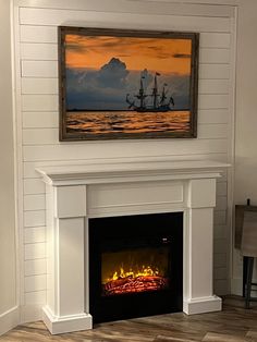 a fire place with a painting on the wall