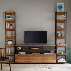 a living room with an entertainment center and bookshelves