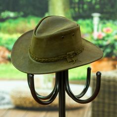 Handcrafted from leather in a stylish olive hue, Gabriela Veronica's newest creation evokes the classic era in each detail meticulously arranged around the design. The hat, made with advanced techniques in Mexico, features a braided accent around the band, finishing with a little ribbon. As a comfortable touch, a polyester textile completes the interior. Classic Leather Hats For Country Events, Classic Flat Brim Hat With Leather Lining, Luxury Leather Wide Brim Hat, Vintage Leather Wide Brim Felt Hat, Classic Adjustable Leather Felt Hat, Elegant Brown Leather Hat, Vintage Leather Felt Hat With Short Brim, Elegant Leather Hats For Rodeo, Luxury Adjustable Hat For Country Events