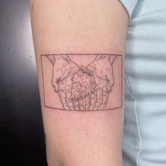 a tattoo on the arm of a woman with two hands holding each other's heart