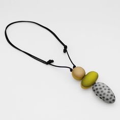 two beads are attached to a string on a white surface with black and gray dots