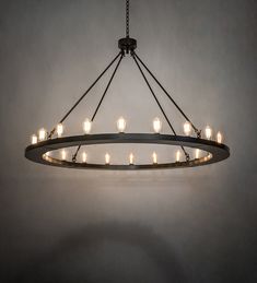 a circular chandelier with lit candles hanging from it