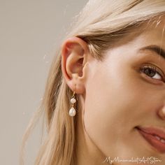 a close up of a person wearing some kind of earring with pearls on it