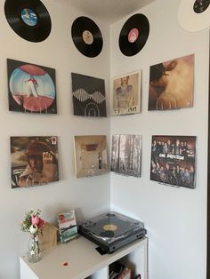 there are many records hanging on the wall next to a table with a record player