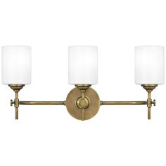 three light bathroom fixture with white shades on the top and bottom lights in antique brass finish