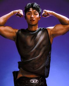 a young man flexing his muscles in front of a purple background