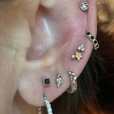 a person with multiple ear piercings on their ears and behind the ear is a star